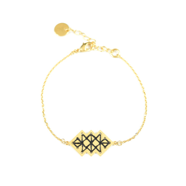 Bracelet doré à l'or fin composé d'un pendentif brodé