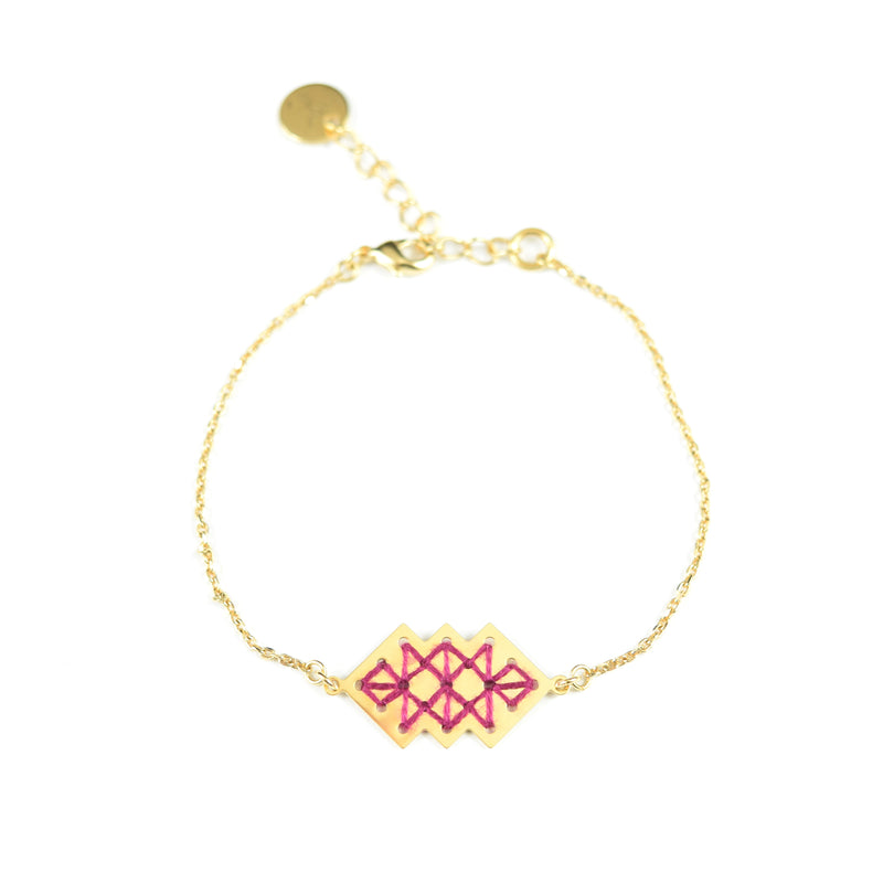 Bracelet doré à l'or fin composé d'un pendentif brodé